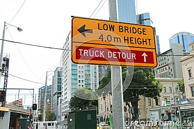 A yellow and black â€™Low Bridge, 4m Heightâ€™ and â€˜Truck Detourâ€™ sign near the Flinders Street rail bridge Editorial Stock Photo